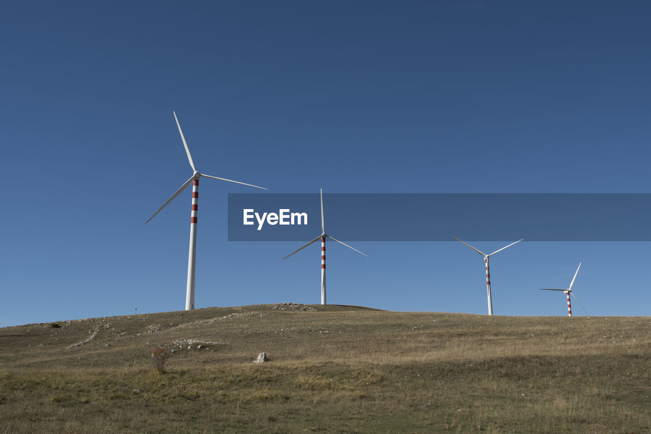 WINDMILL ON FIELD AGAINST CLEAR SKY