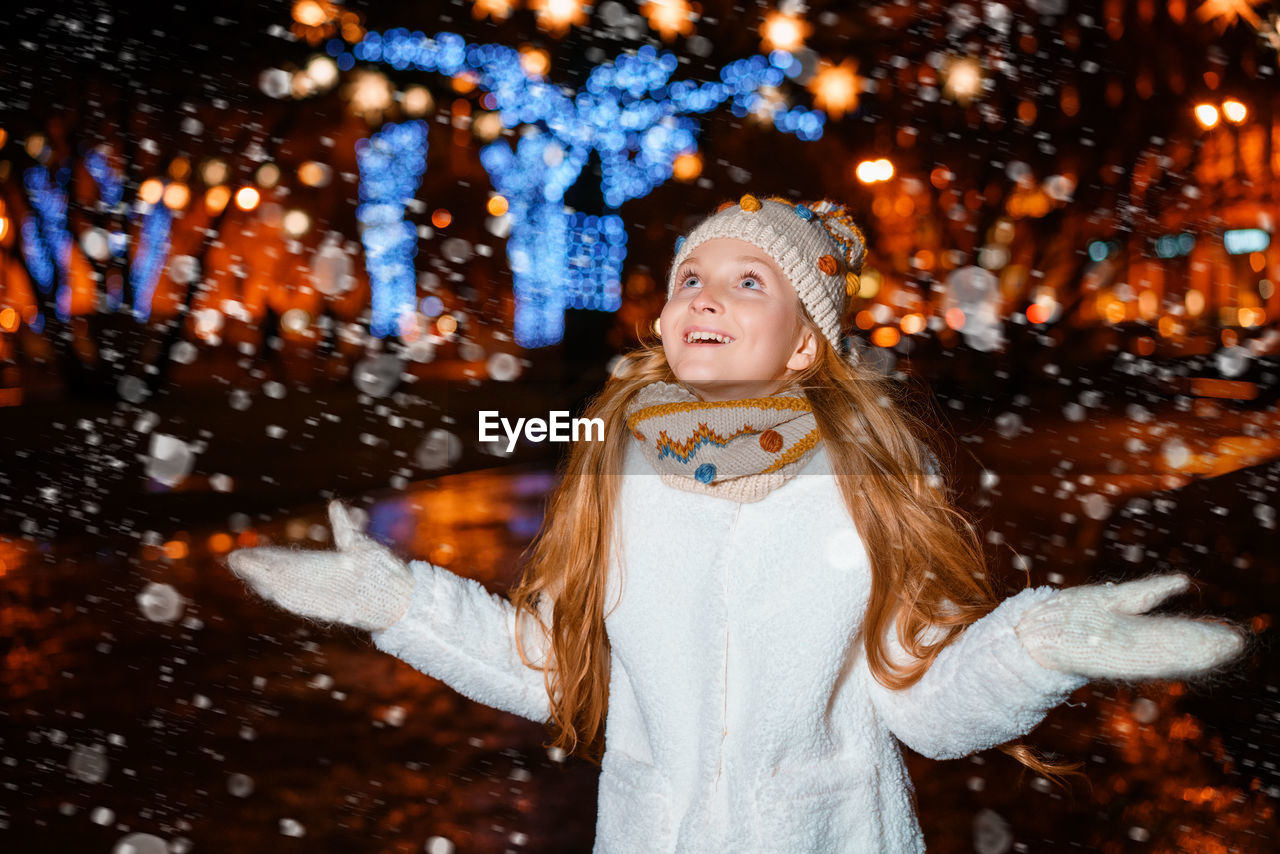 Teenage girl on a festive evening on the street in winter