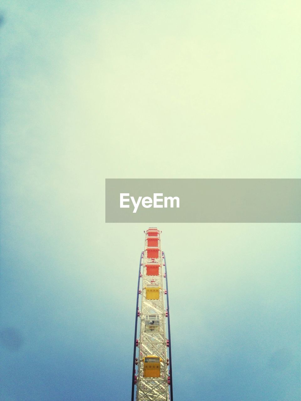 Low angle view of ferris wheel against blue sky