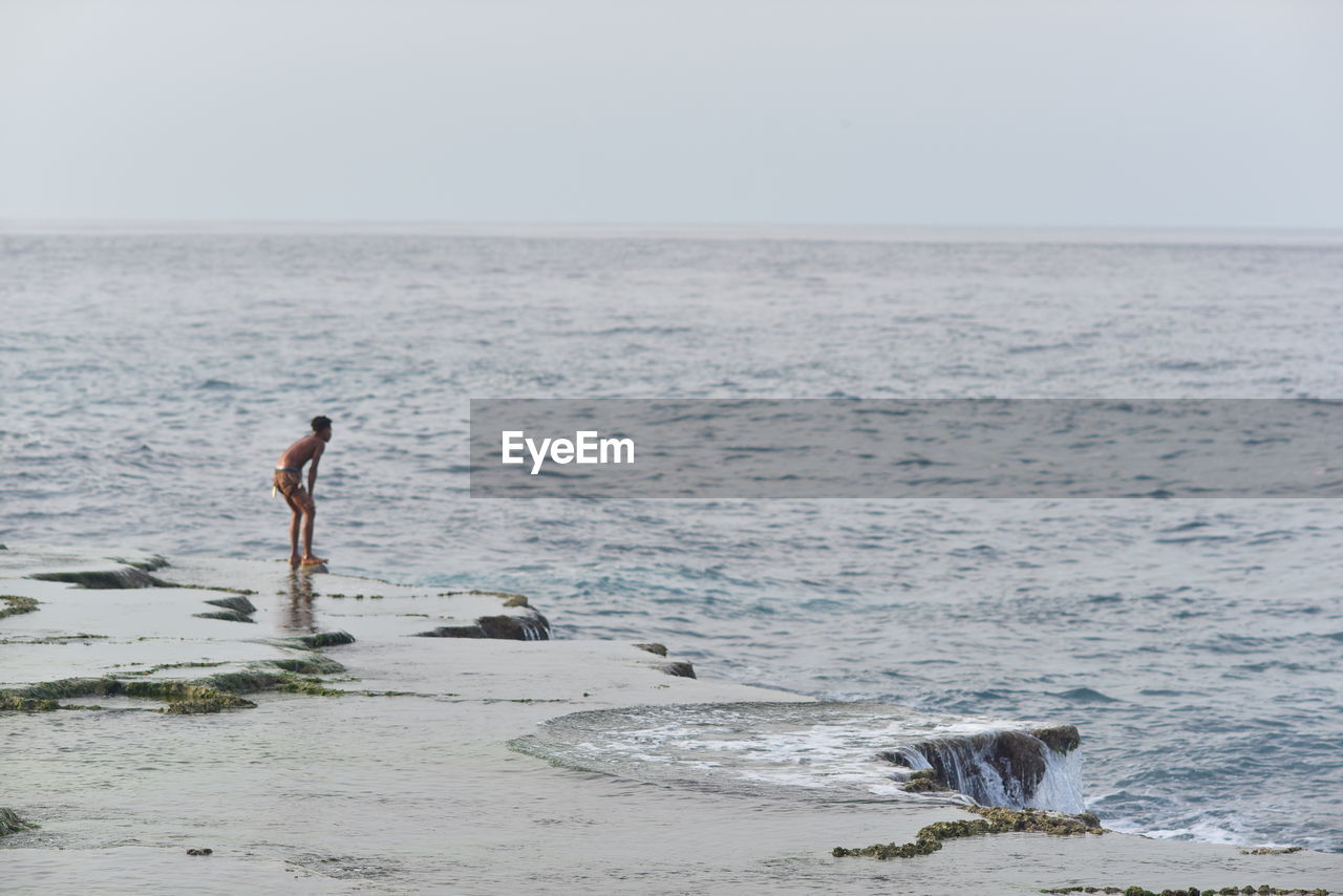 rear view of man walking on beach