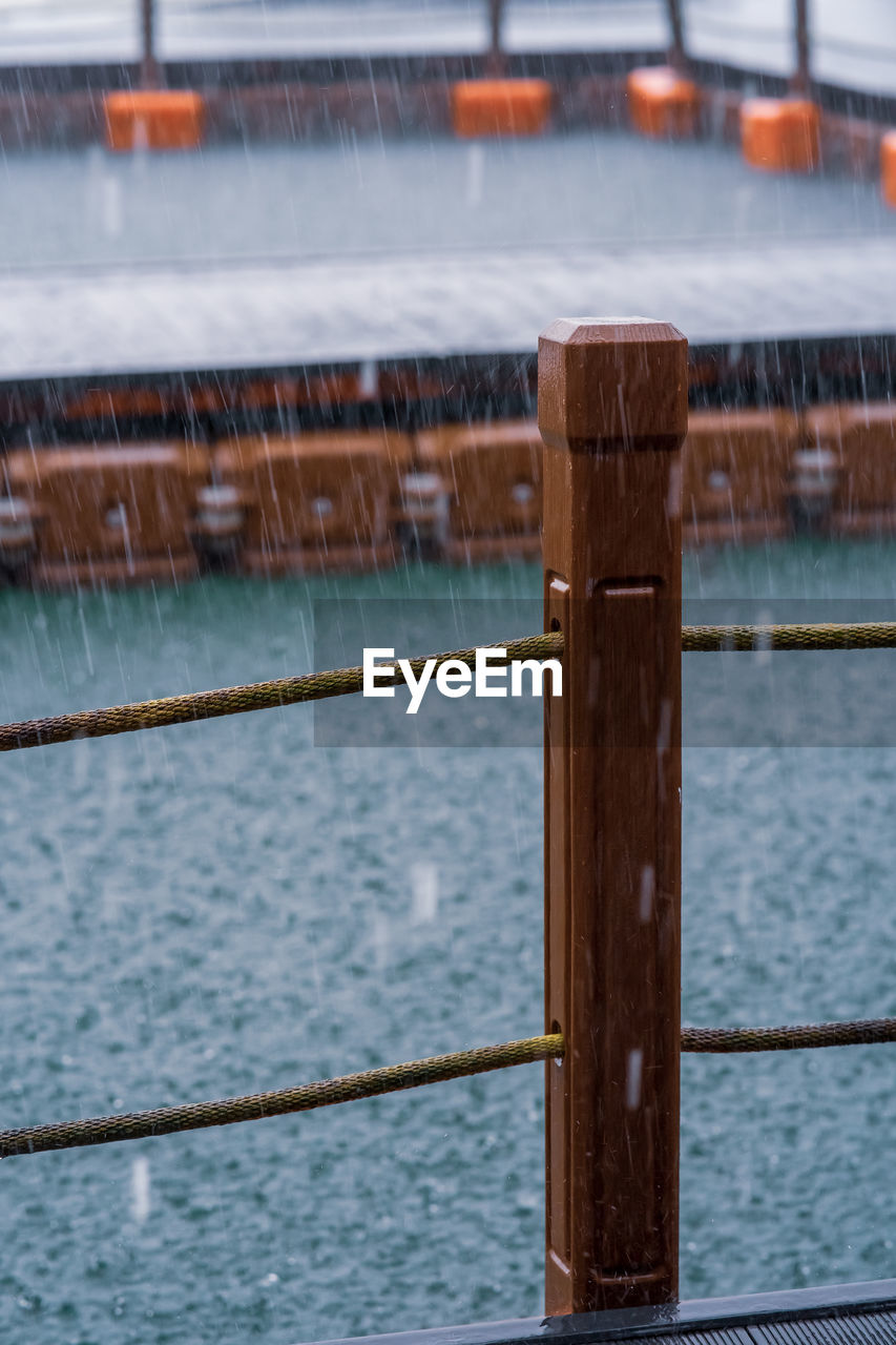 Wooden pole with mooring rope under the heavy rain. tourism, monsoon and tropical country.