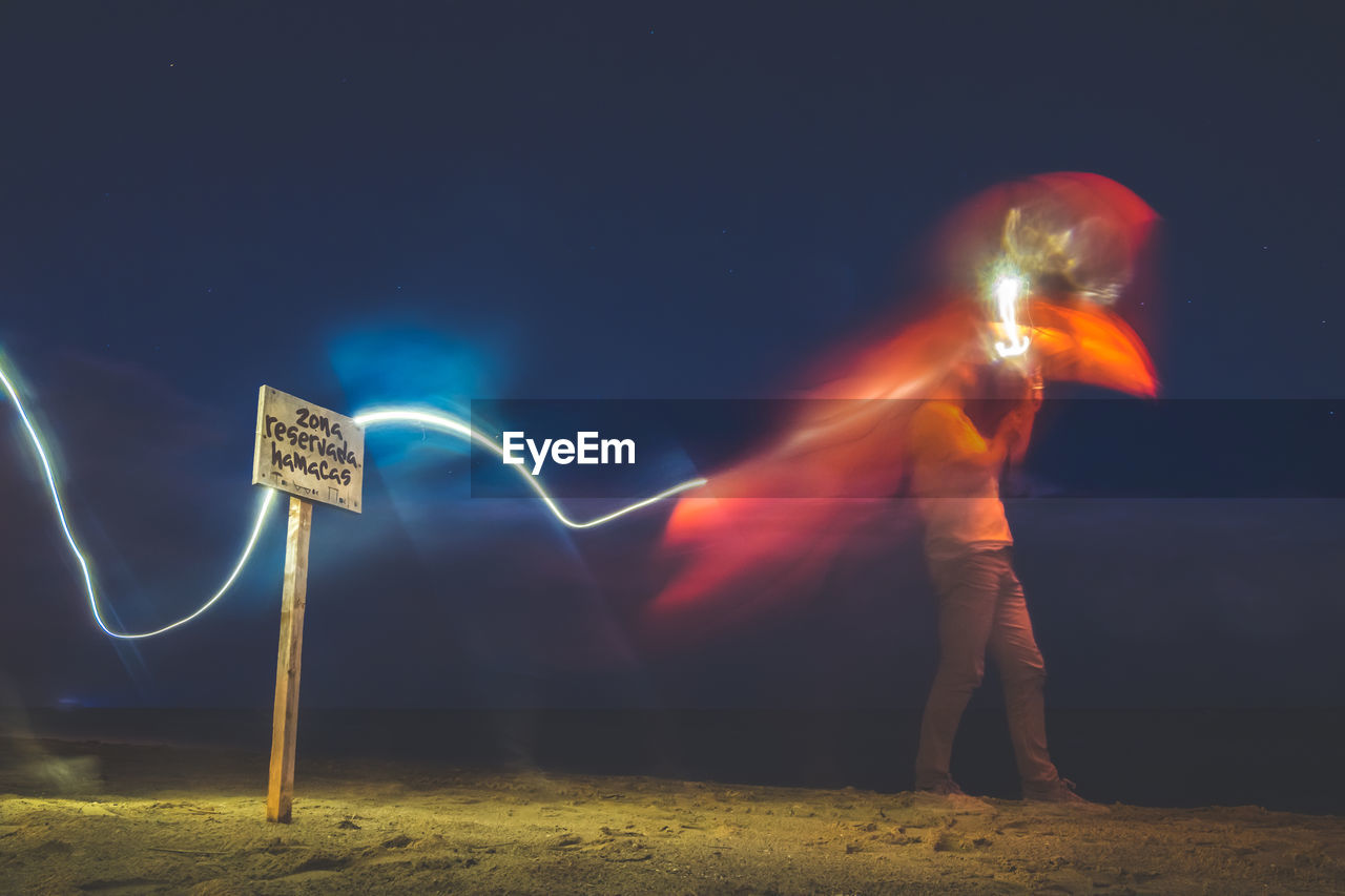 low angle view of man standing on field against sky at night