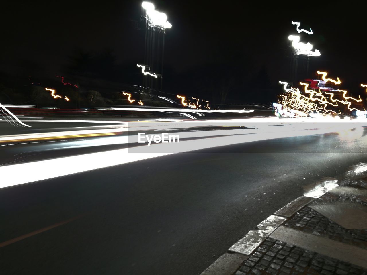 LIGHT TRAILS ON STREET AT NIGHT