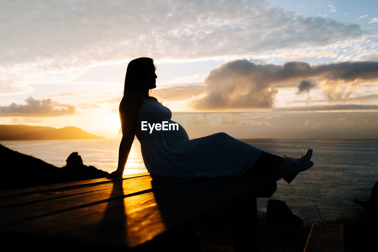 SILHOUETTE WOMAN ON BEACH DURING SUNSET