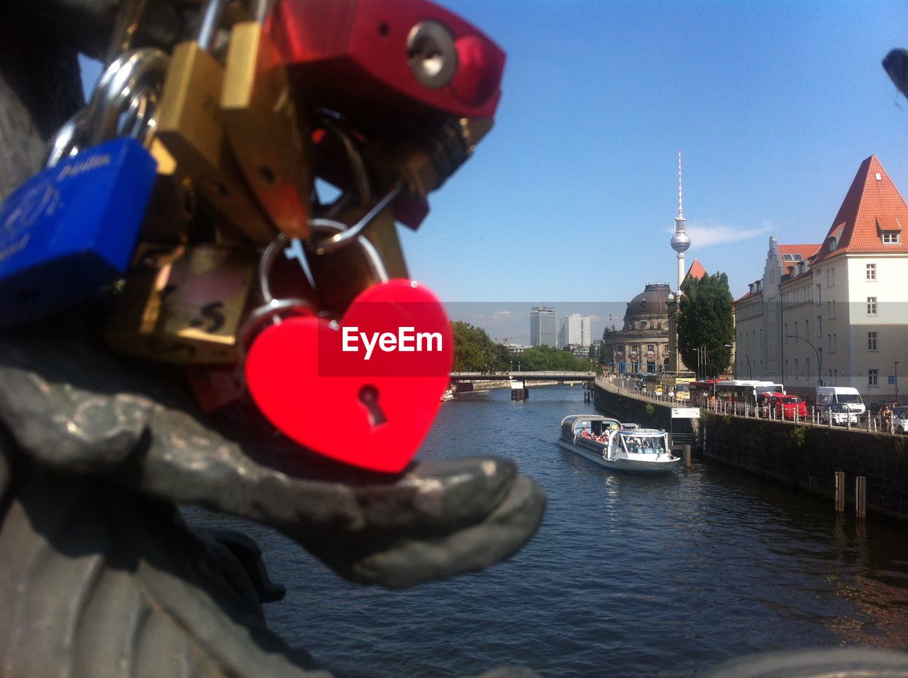 Padlocks on bridge over river in city