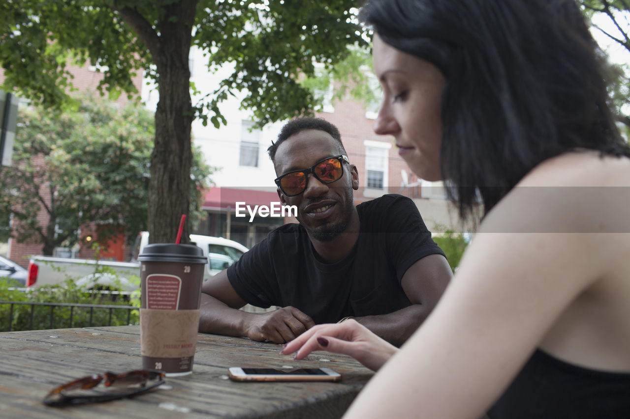 A young man and a young woman at a picnic table.