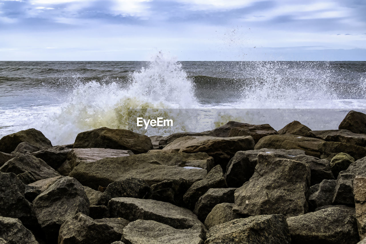 SCENIC VIEW OF SEA WAVES SPLASHING ON ROCKS