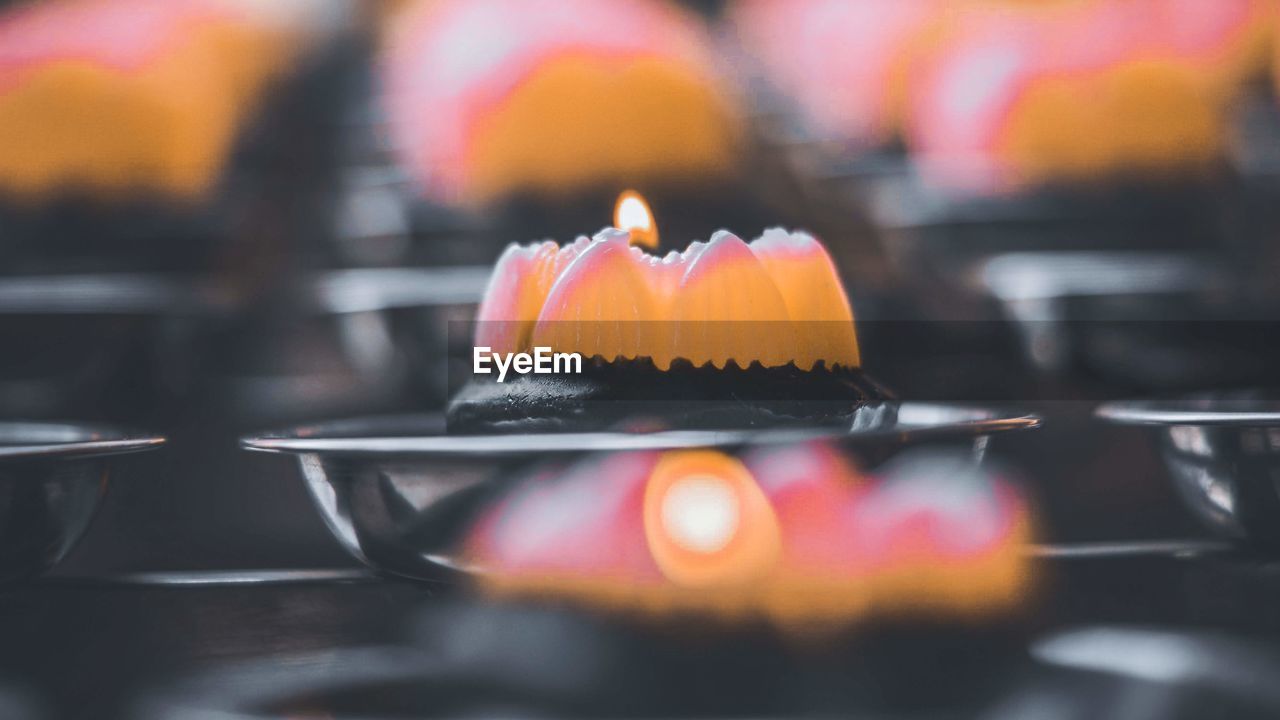 Close-up of lit candles inside chinese temple 