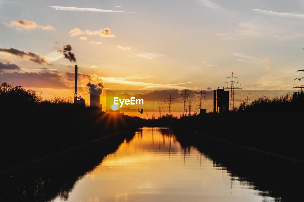 SILHOUETTE OF FACTORY AT SUNSET