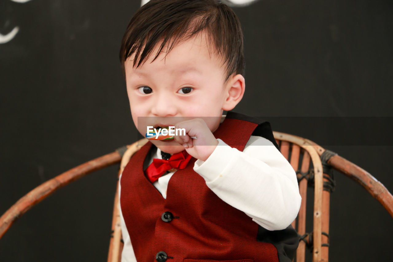 Portrait of cute boy eating candy