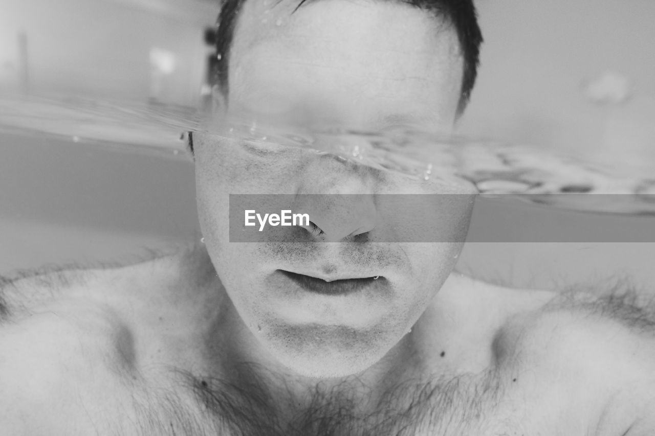 Close-up of shirtless man swimming in pool