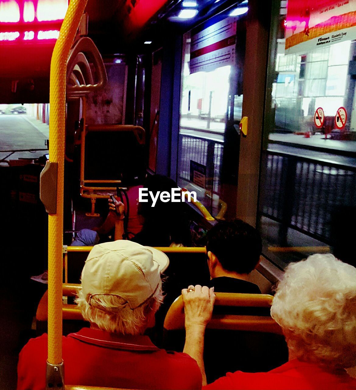 Rear view of senior couple sitting in bus