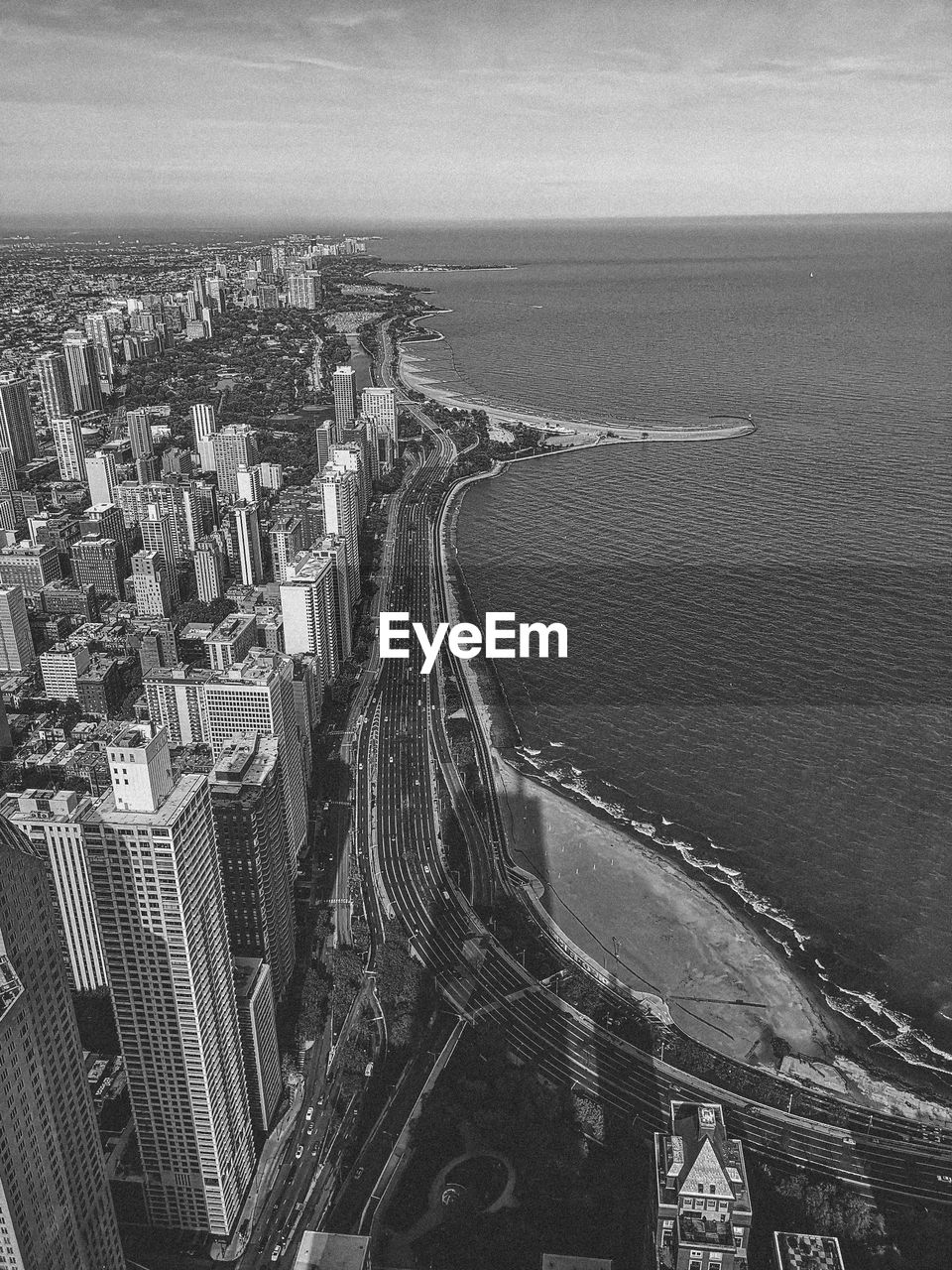 High angle view of sea by buildings against sky