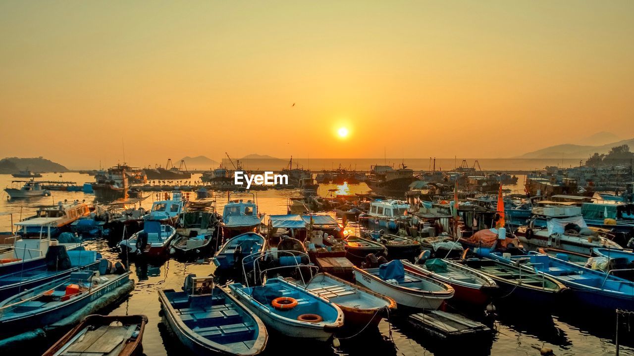 HIGH ANGLE VIEW OF BOATS MOORED AT HARBOR AGAINST BUILDINGS