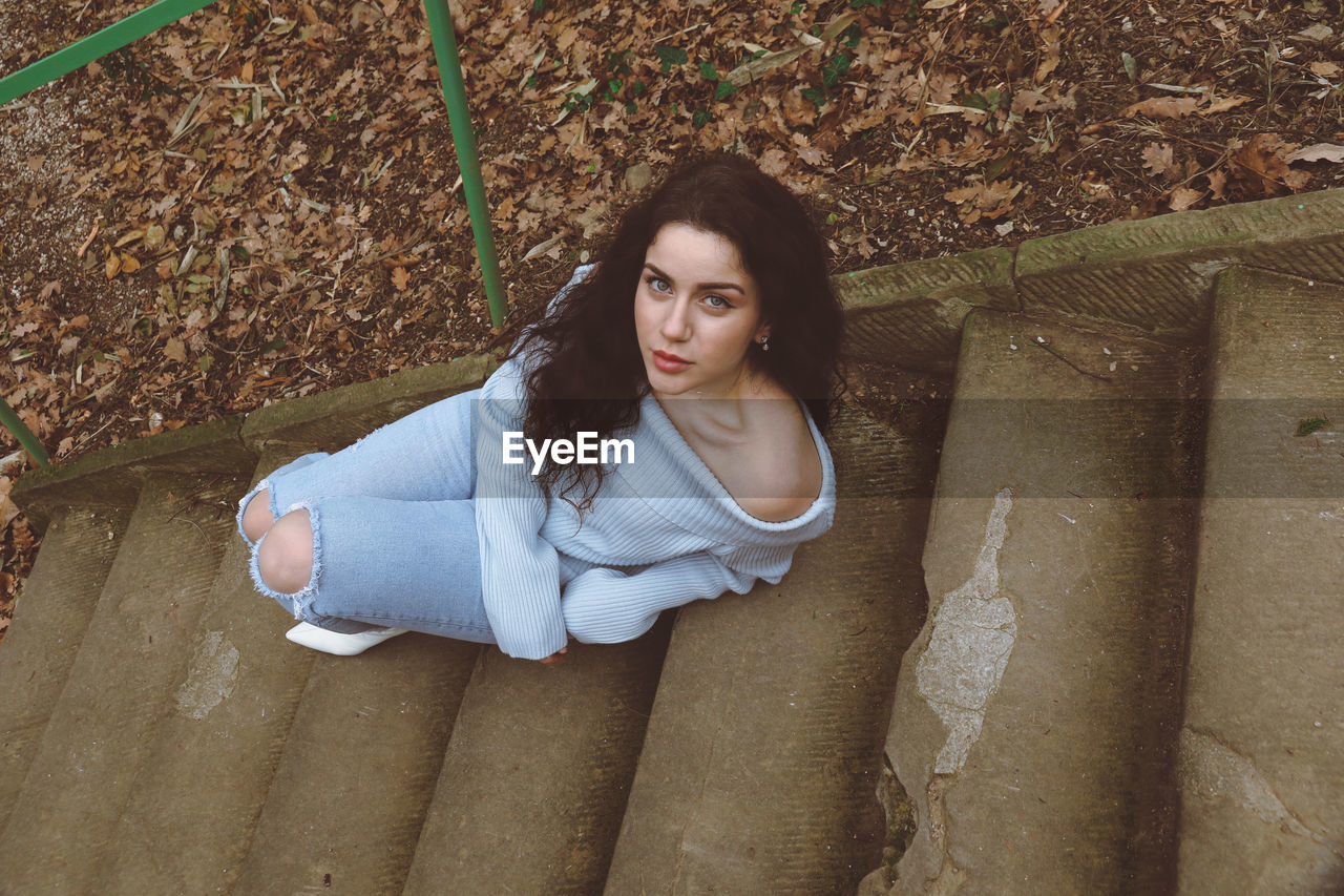 Portrait of beautiful young woman sitting outdoors