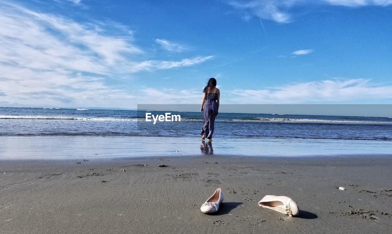 MAN ON BEACH AGAINST SKY