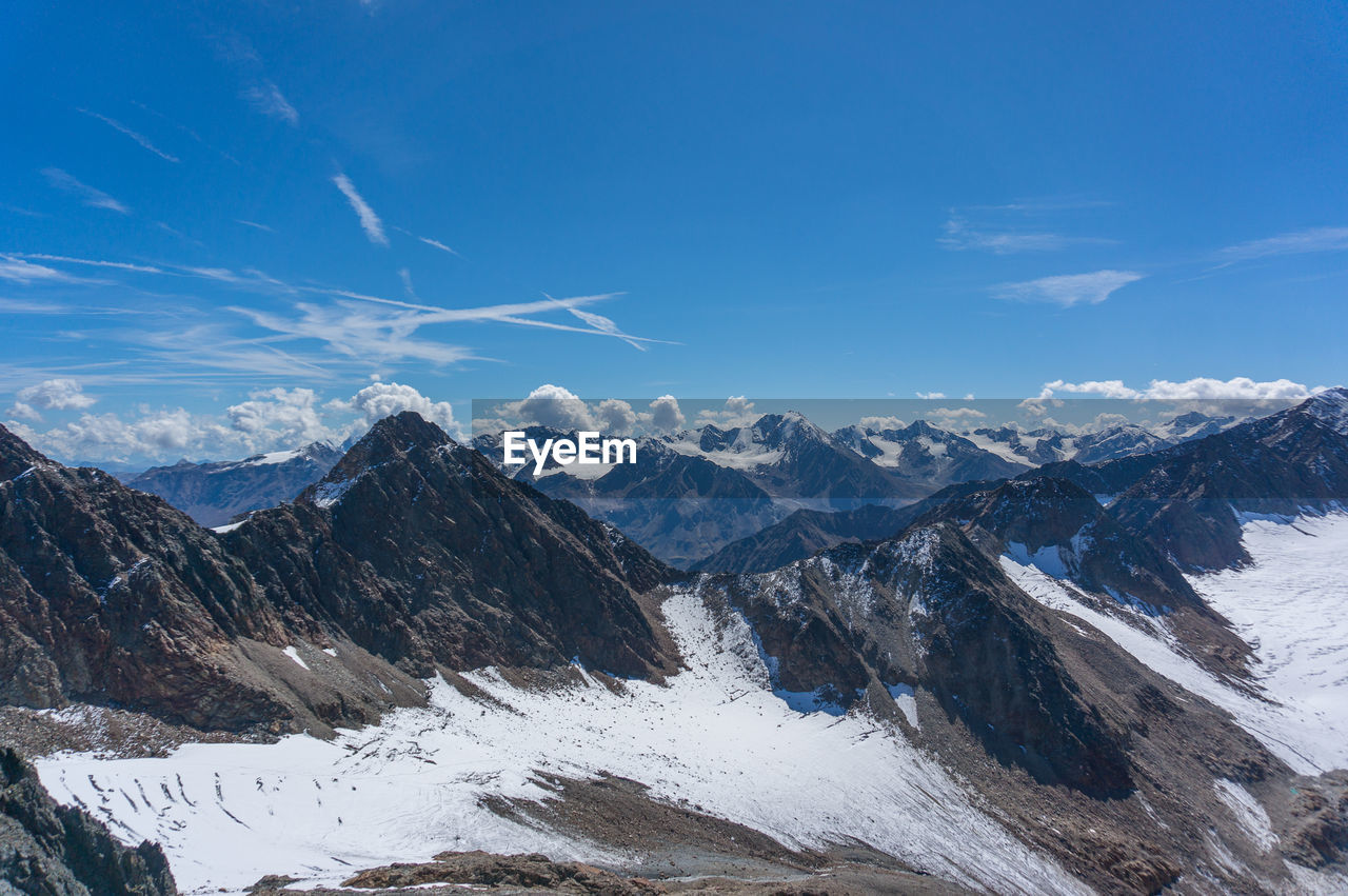 Scenic view of snowcapped mountains against blue sky