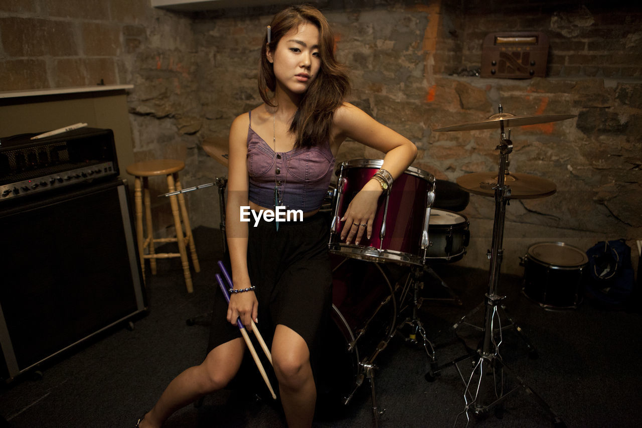 Young woman standing by her drum kit