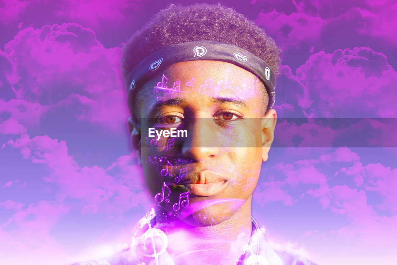 PORTRAIT OF YOUNG MAN AGAINST PINK PURPLE