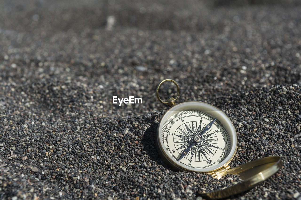 Close-up of compass at beach