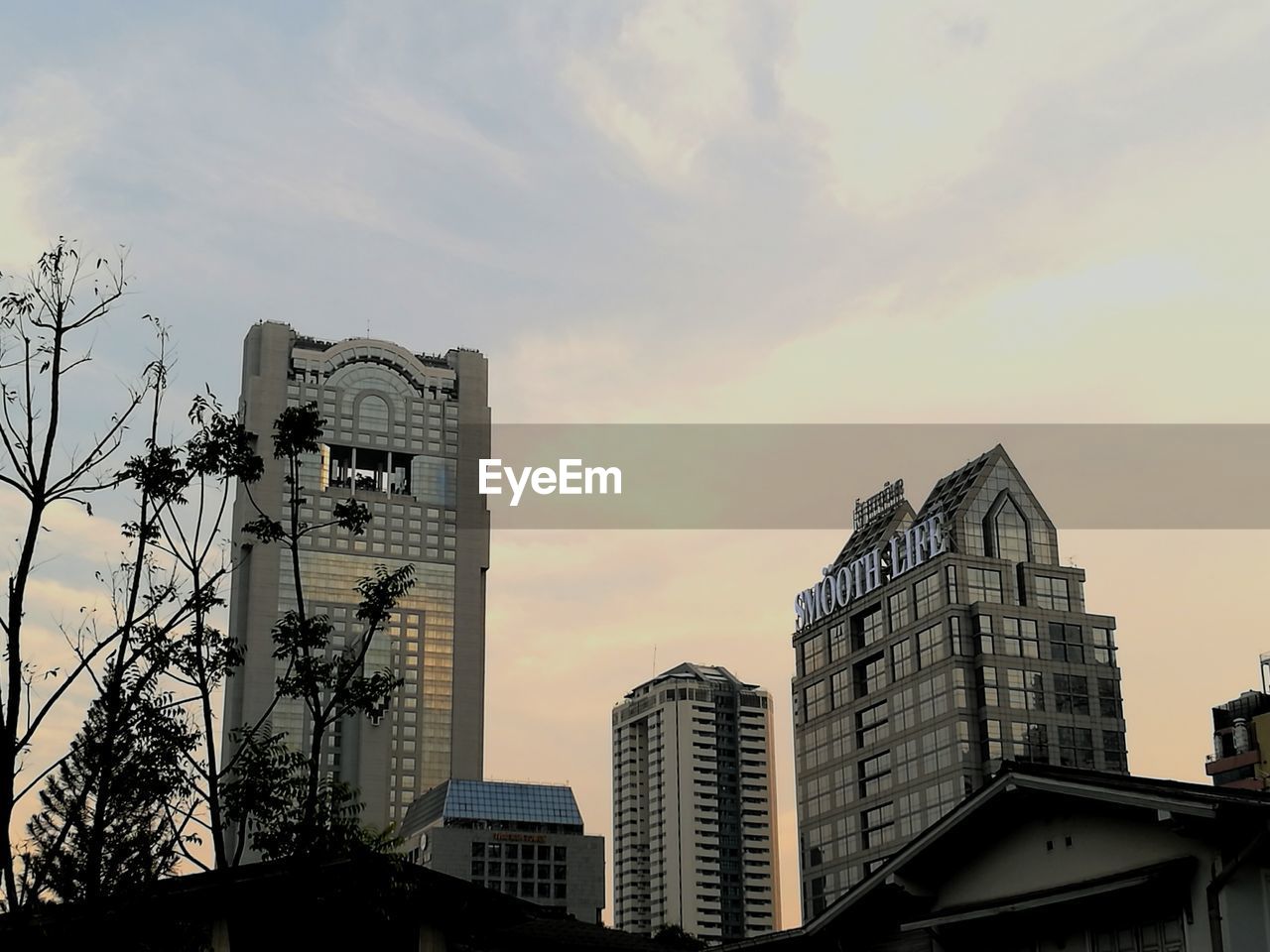 Low angle view of skyscraper against sky during sunset