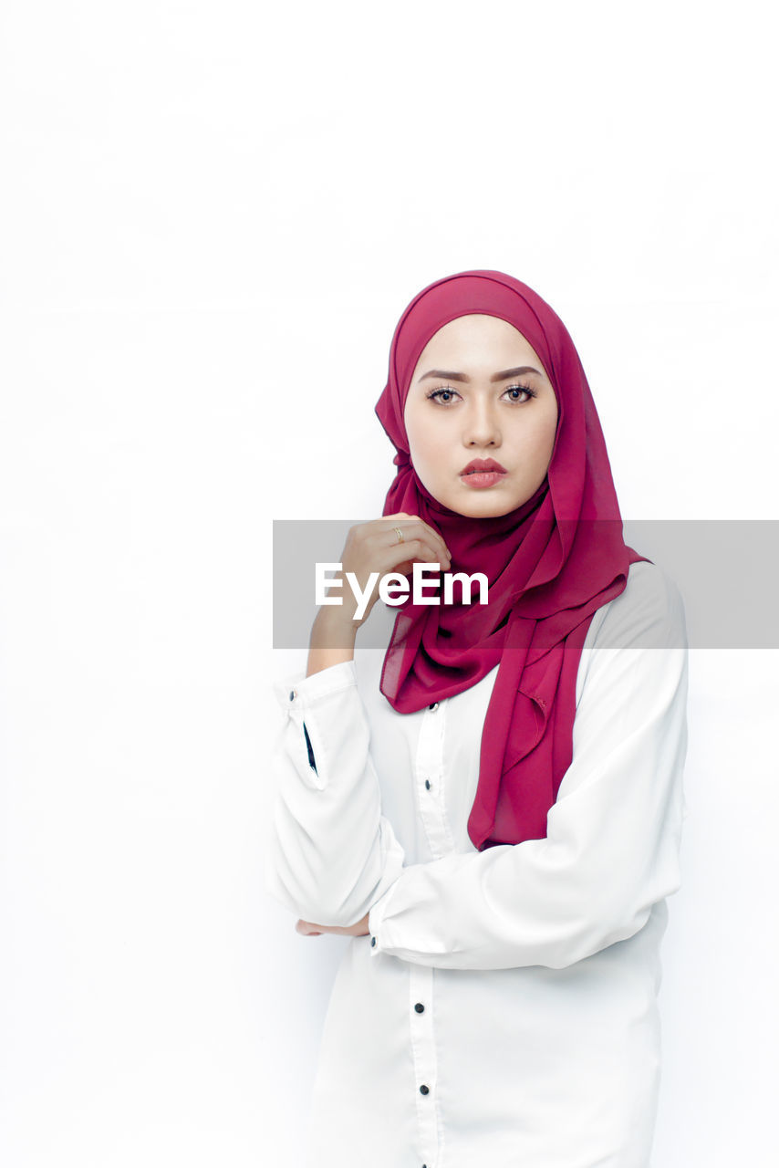 Portrait of woman wearing hijab against white background