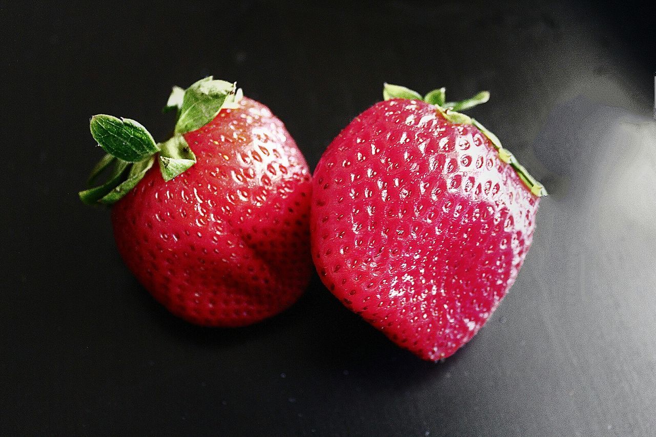 CLOSE-UP OF RED FRUIT OVER WHITE BACKGROUND