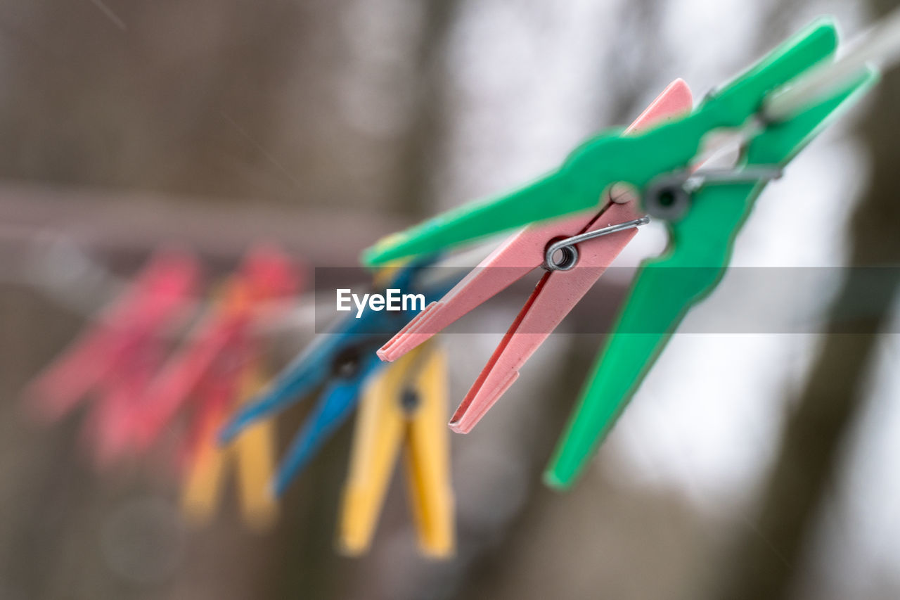 Close-up of multi colored clothespins hanging on clothesline