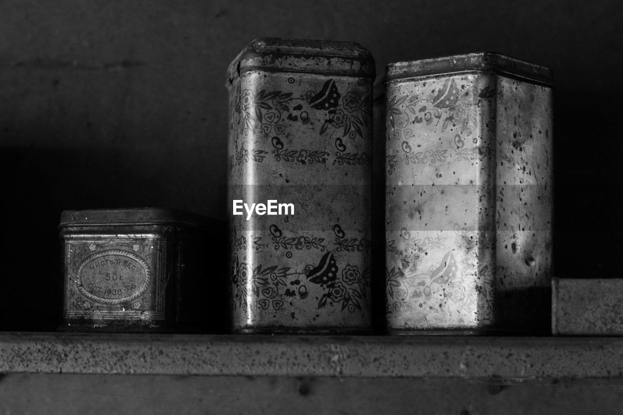 Rusty metallic boxes on shelf against wall