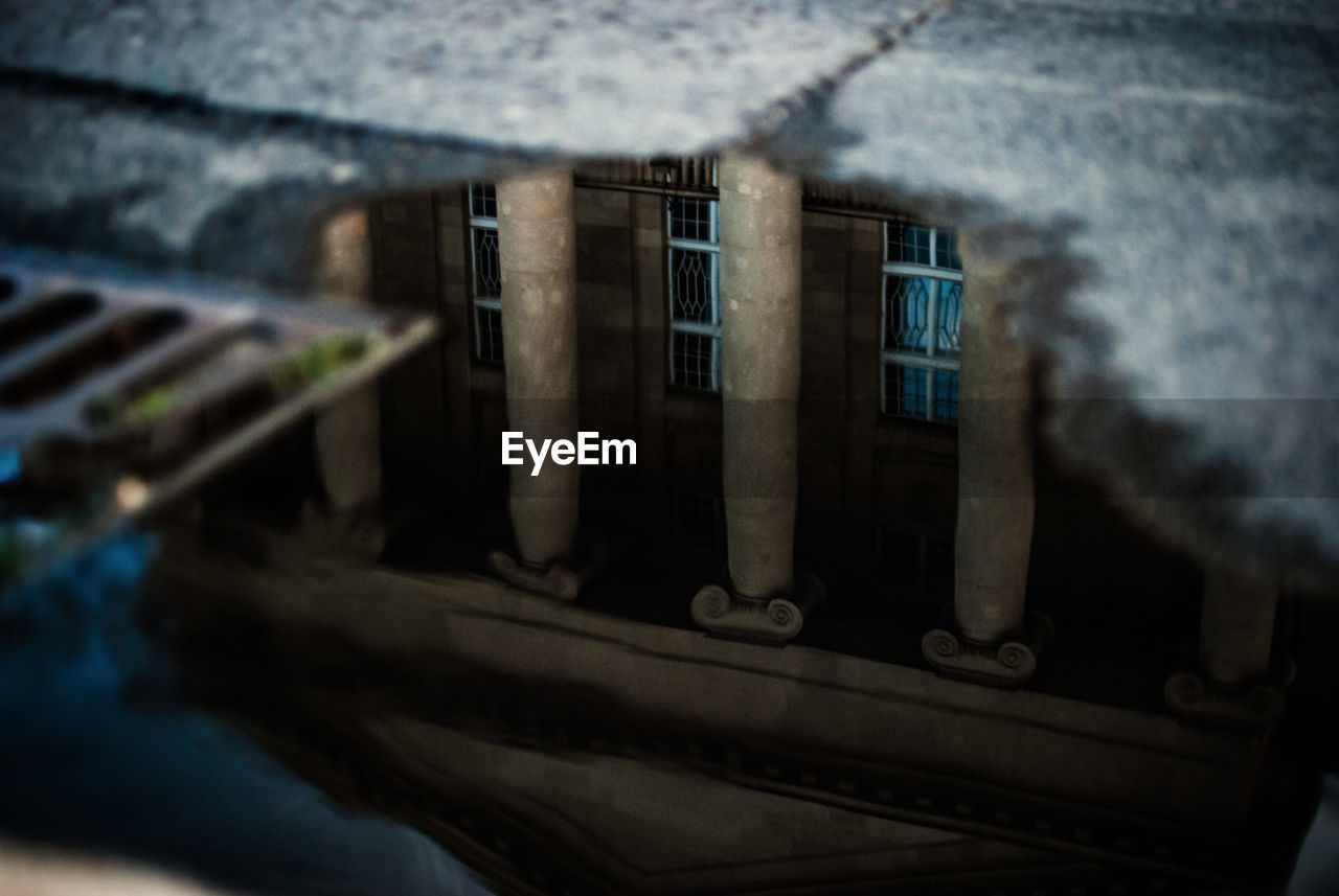 Reflection of historic building in puddle