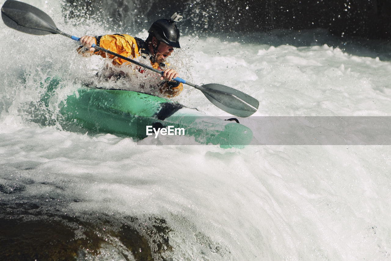 Whitewater kayaker descending waterfall rapids