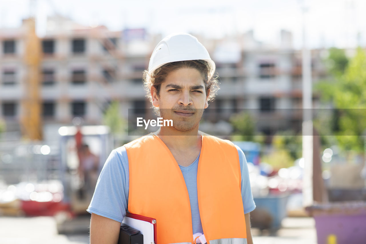 Young construction engineer with helmet working outside