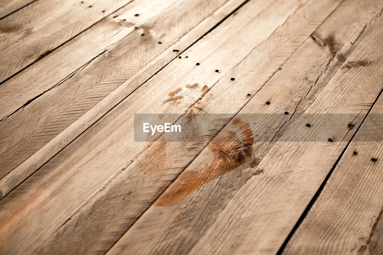 High angle view of footprint on wooden plank