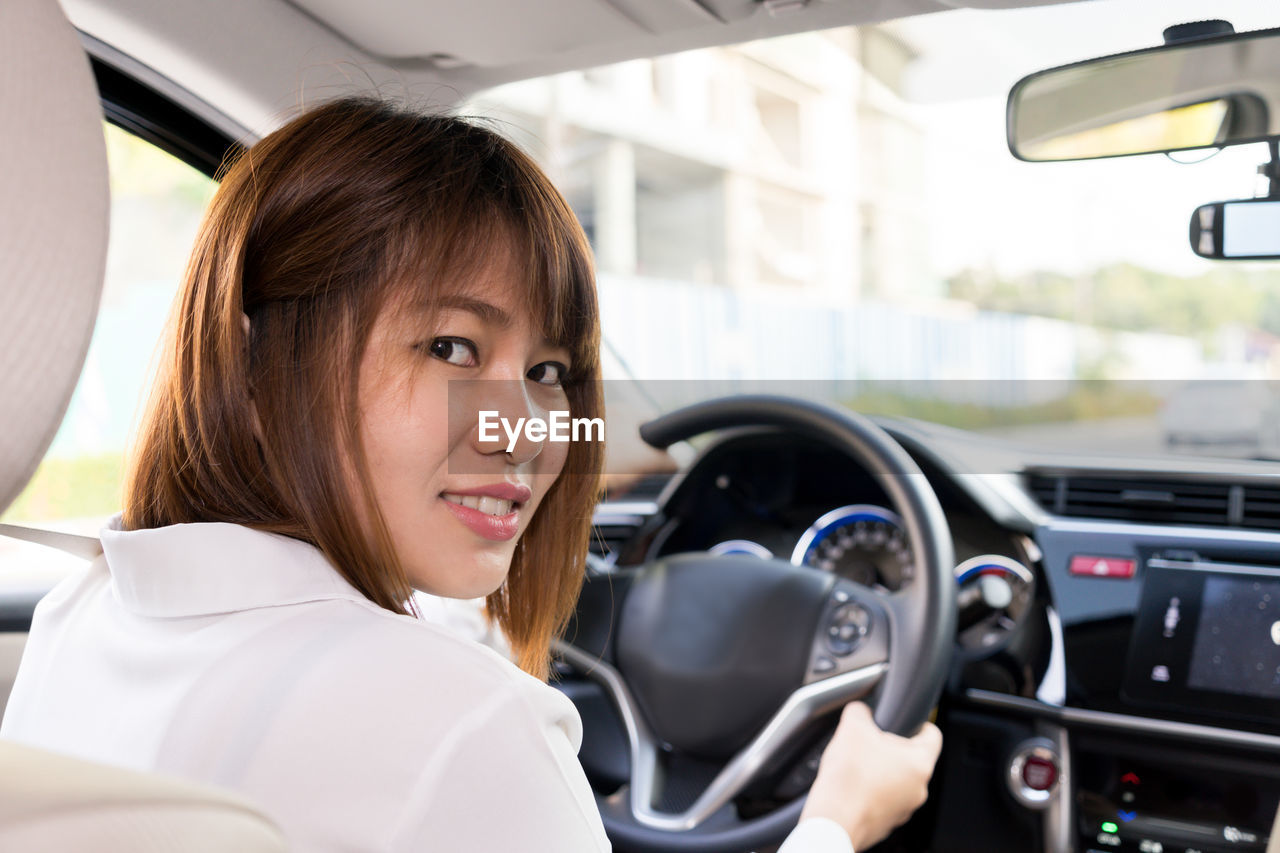 Portrait of smiling woman driving car