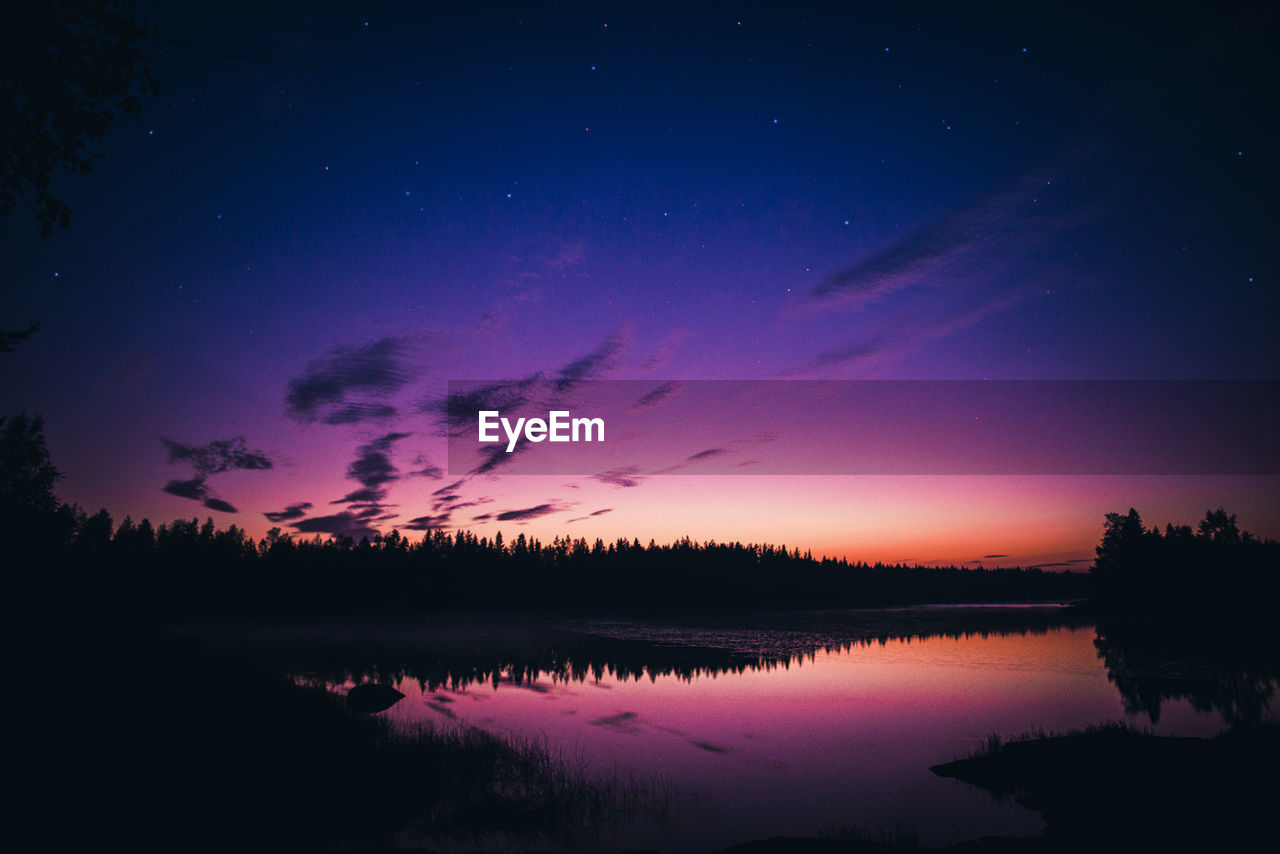 Scenic view of river against sky at night