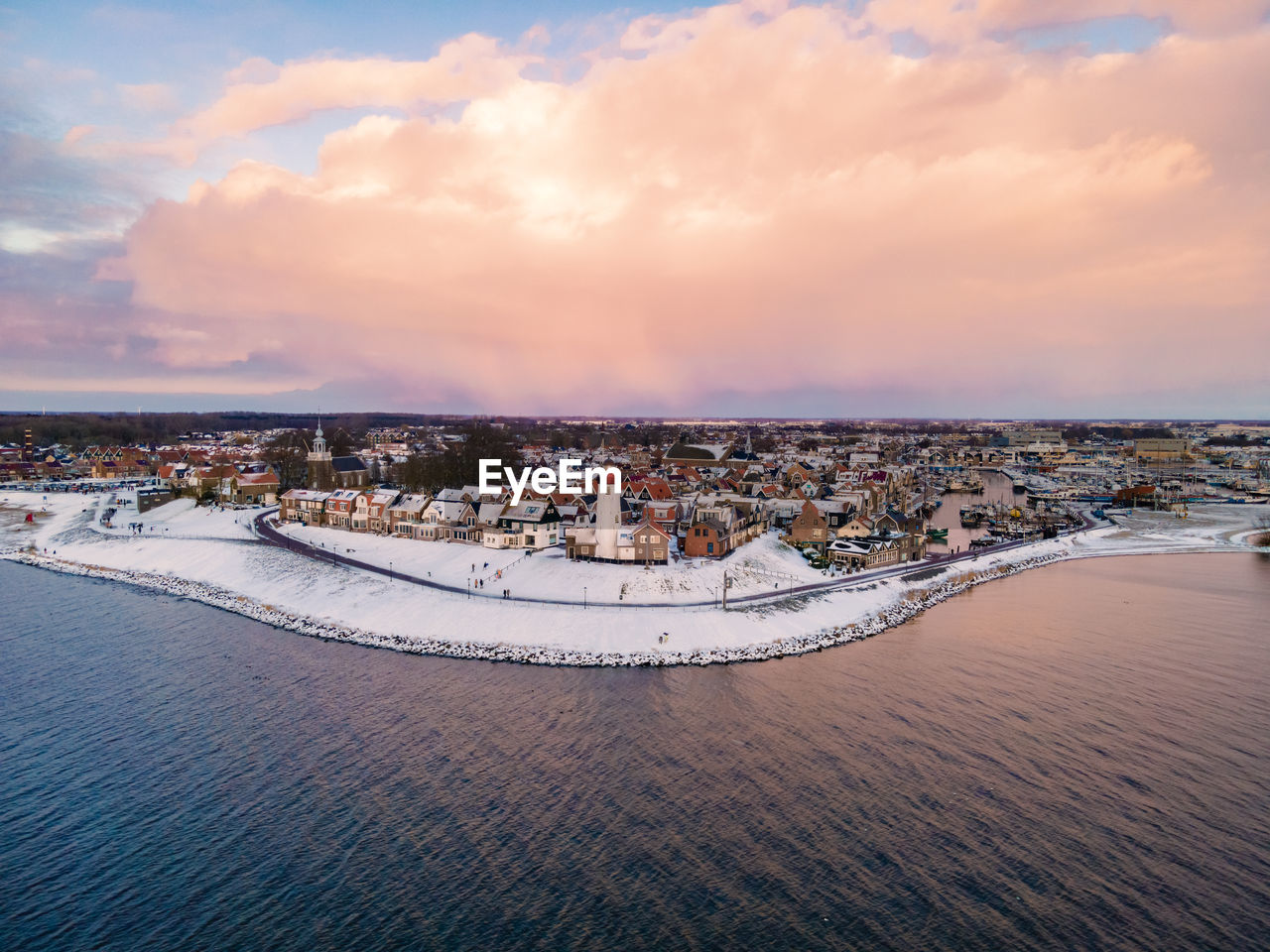 AERIAL VIEW OF CITY BY SEA AGAINST SKY