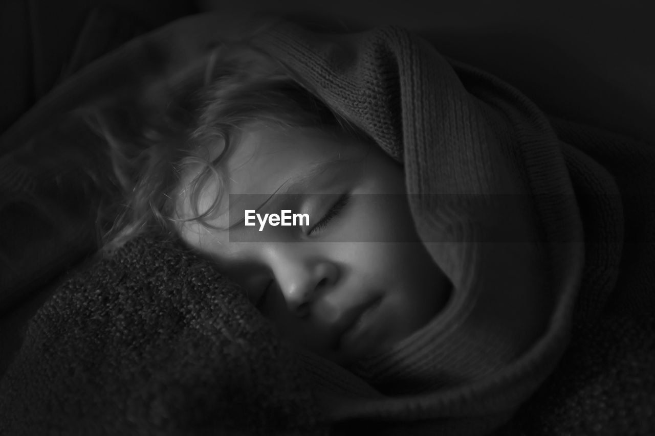 Close-up of girl sleeping on bed at home