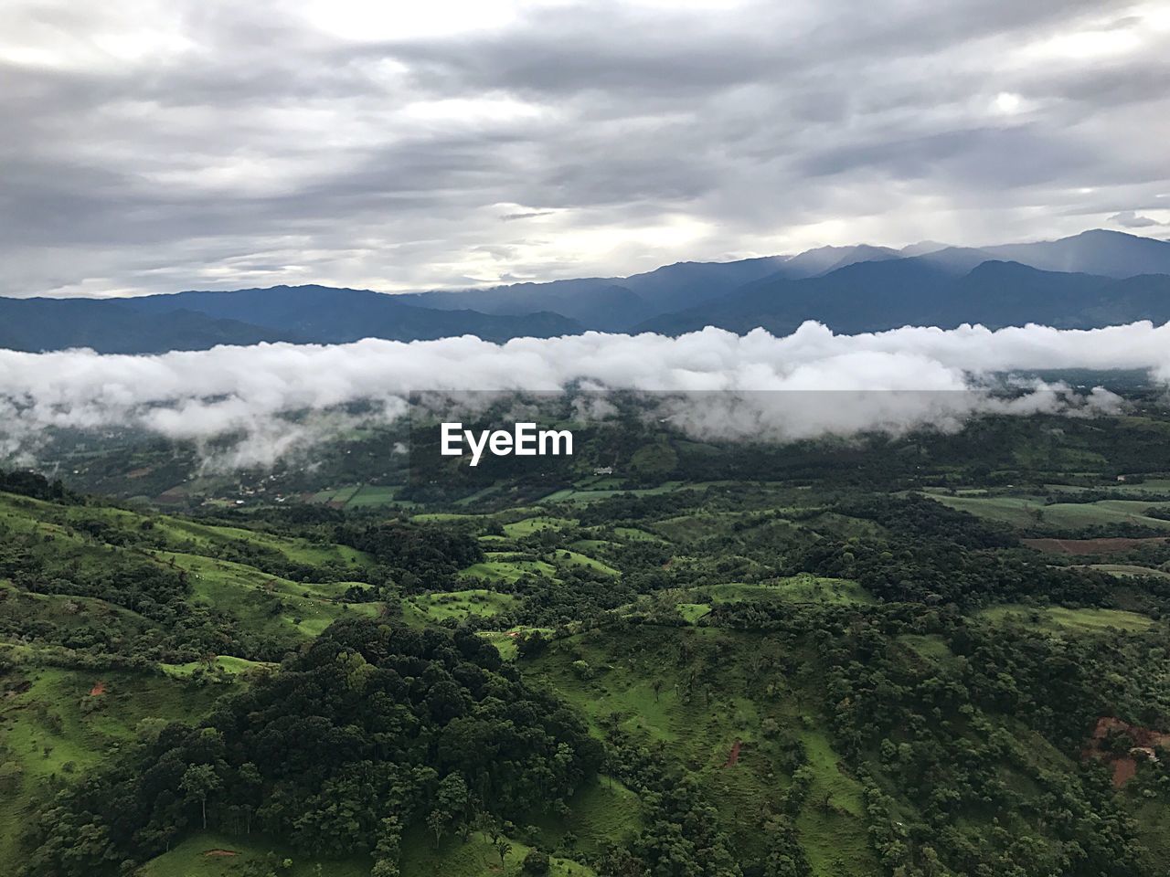 SCENIC VIEW OF MOUNTAINS AGAINST CLOUDY SKY