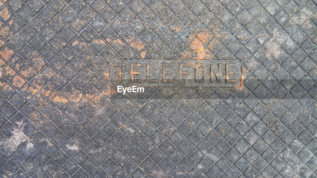 HIGH ANGLE VIEW OF TEXT WRITTEN ON METAL