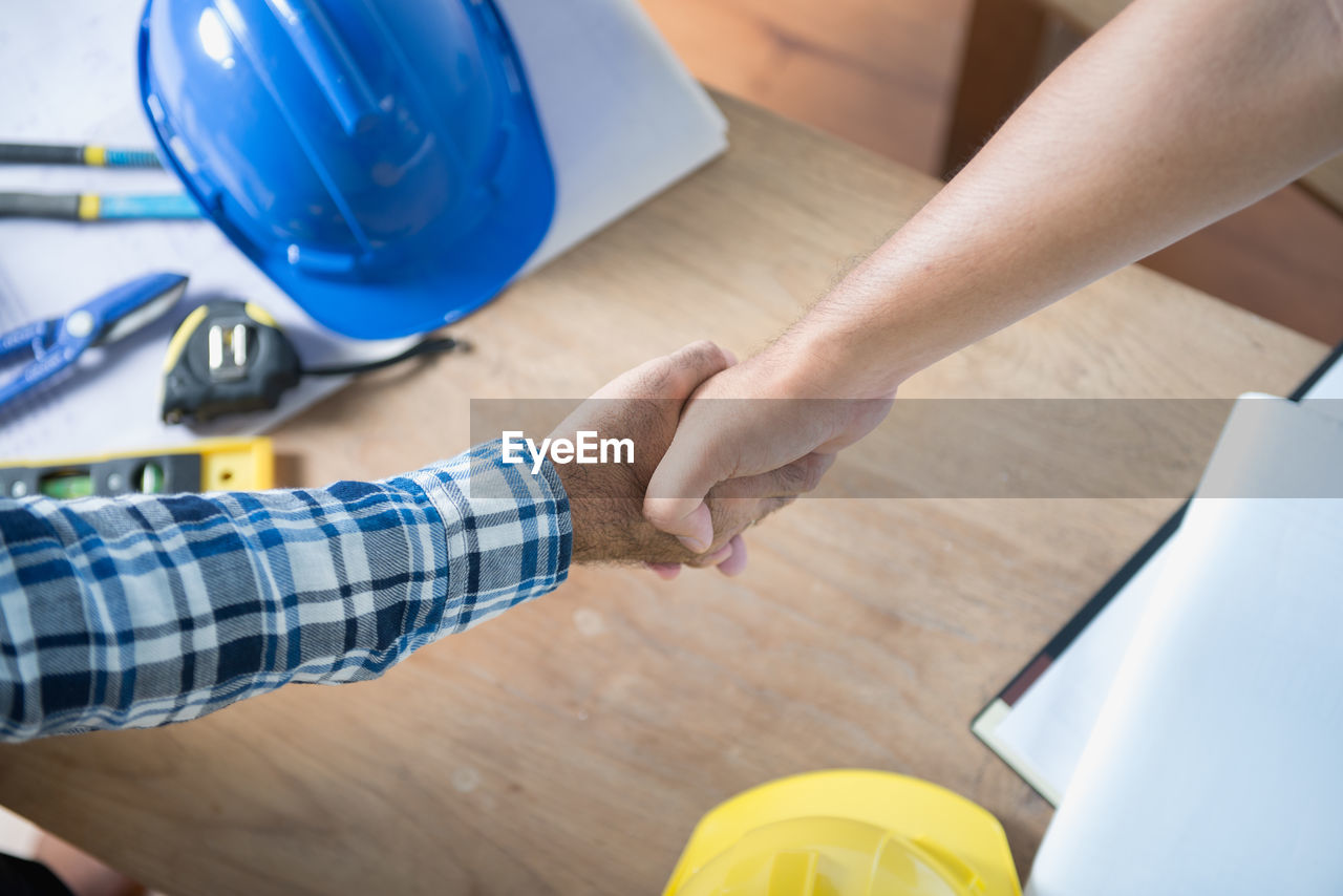 Cropped image of business people giving handshake in office