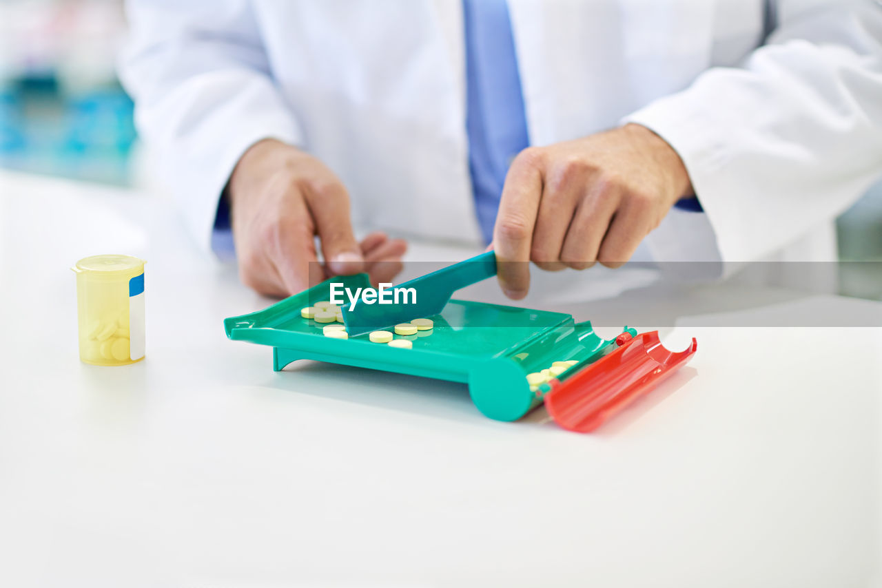 midsection of man playing with toy blocks against white background