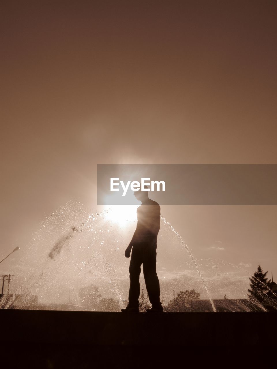 Silhouette man standing against sky during sunset