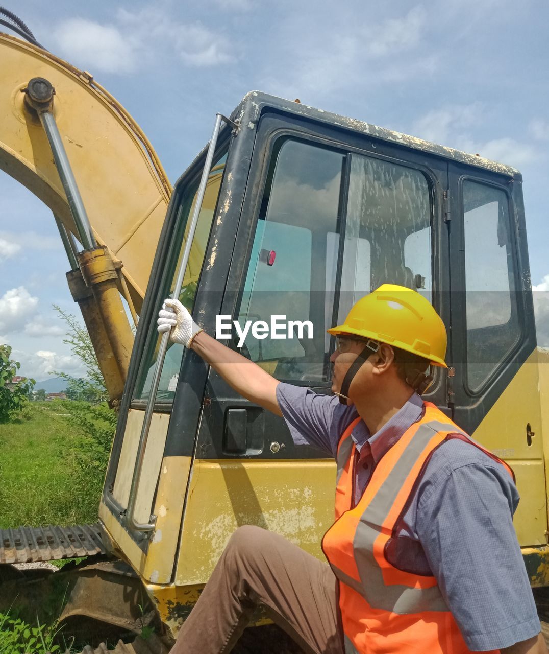 SIDE VIEW OF MAN WORKING ON MOTORCYCLE