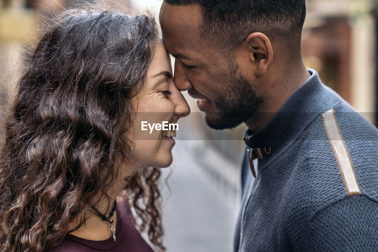 Side view of couple embracing outdoors