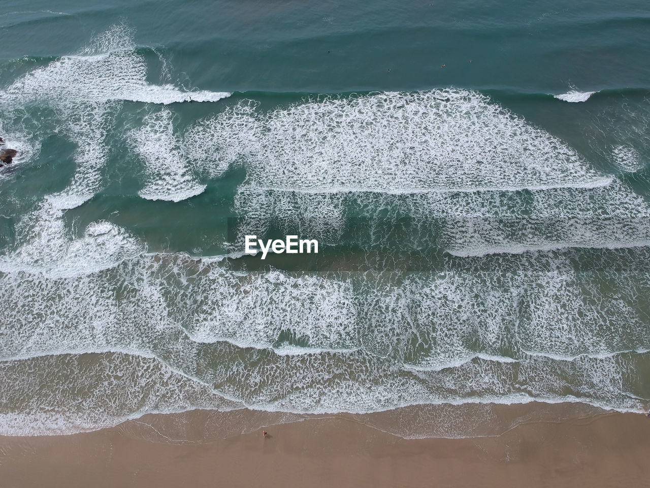 High angle view of waves rushing towards shore