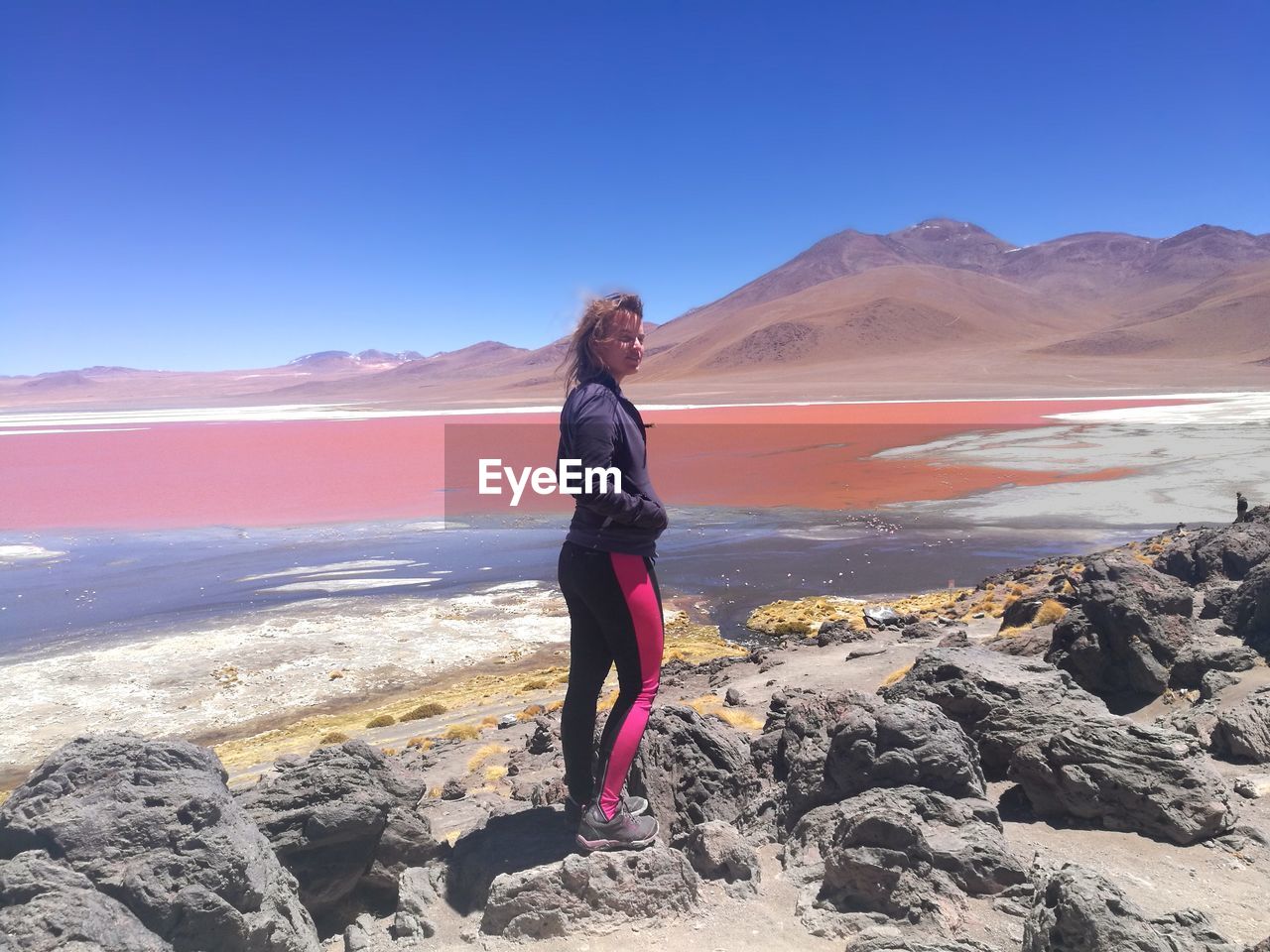 Portrait of smiling young woman standing on rock
