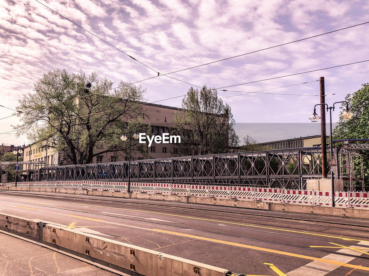 VIEW OF RAILROAD TRACKS BY STREET AGAINST SKY