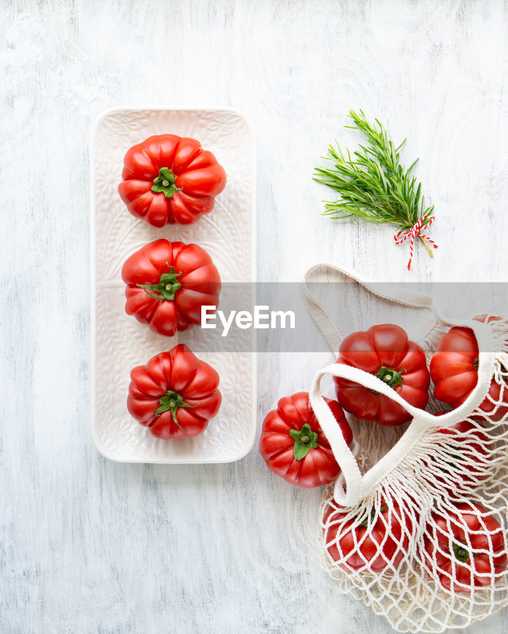 Still life of beautiful ripe tomatoes and rosemary.