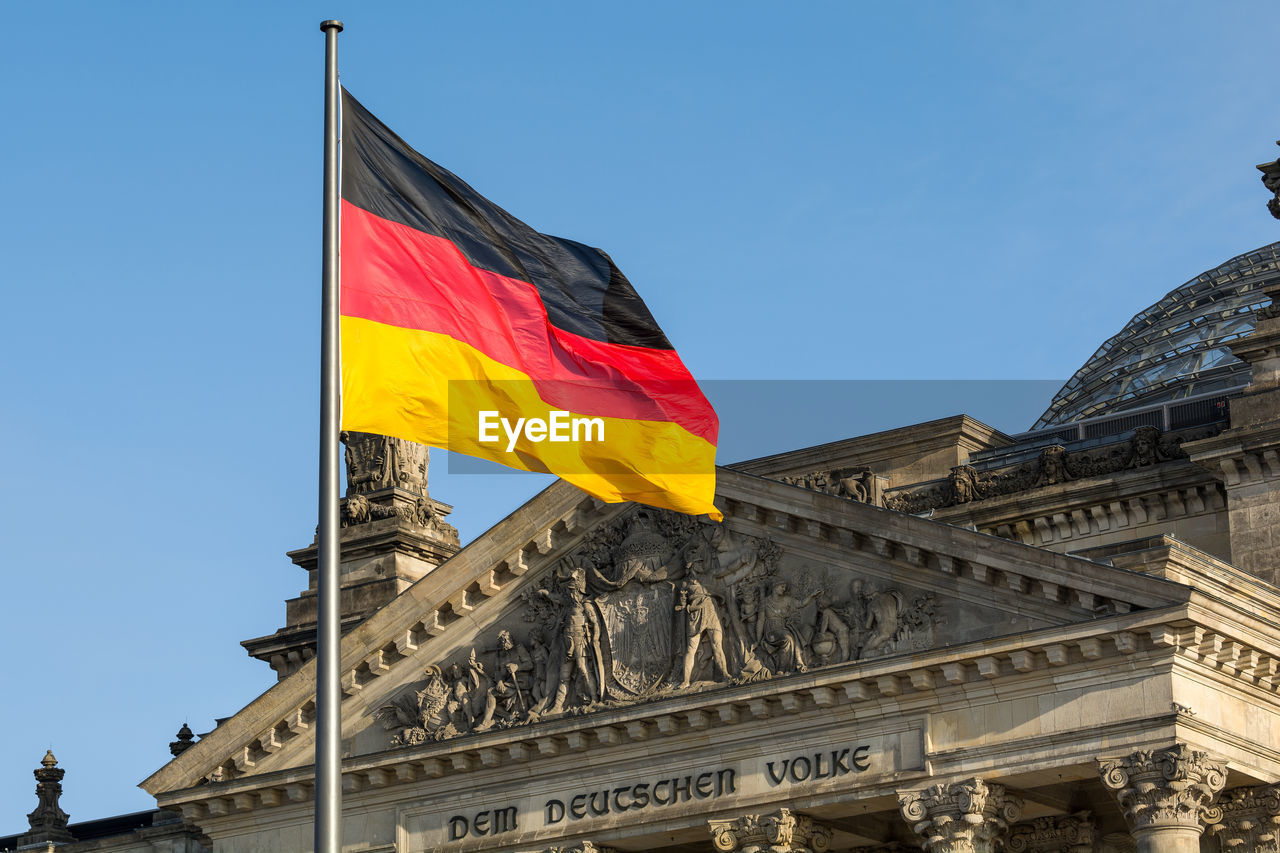 German flag waving front of reichstag building. berlin, germany