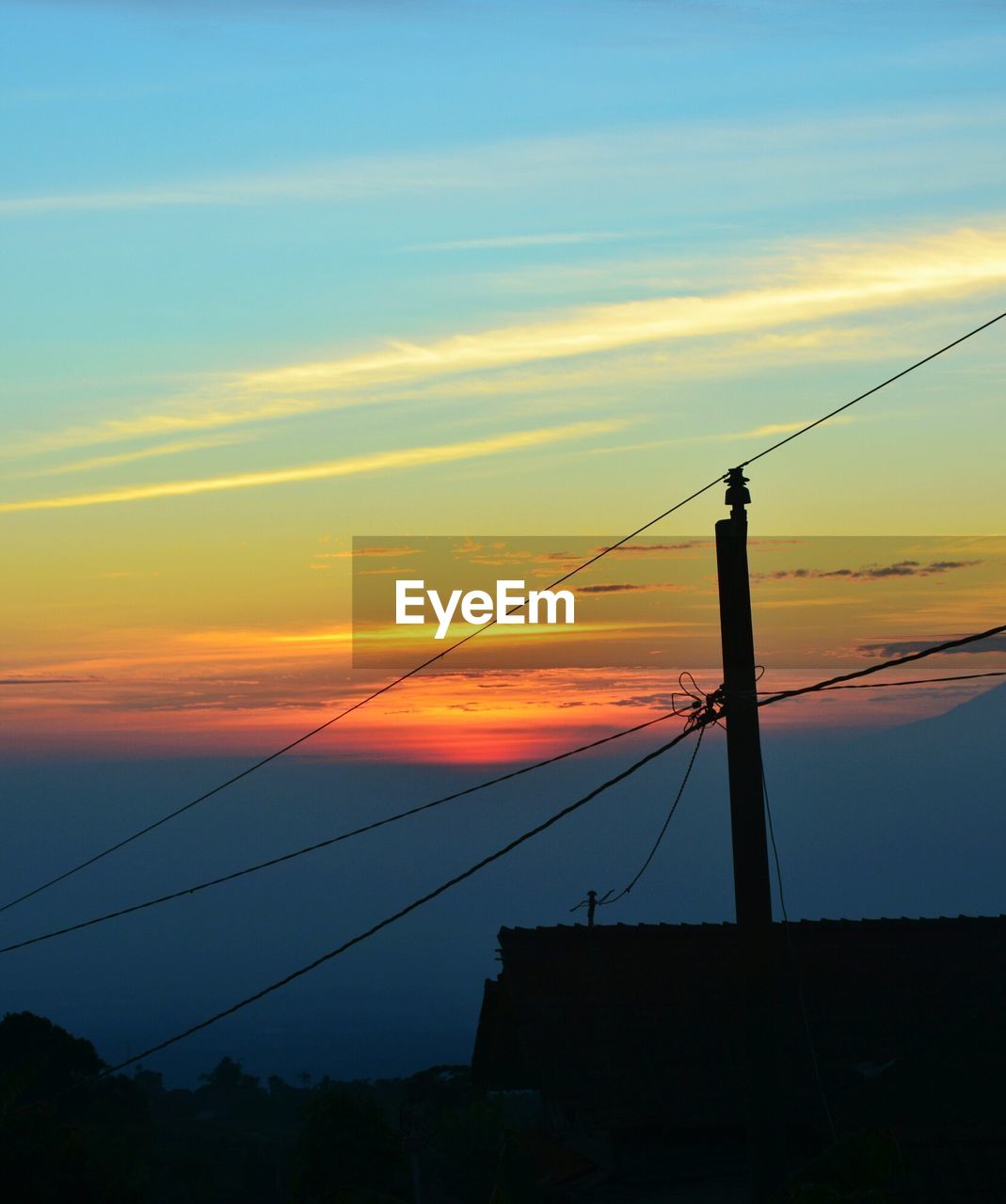 LOW ANGLE VIEW OF POWER LINES AGAINST SKY DURING SUNSET